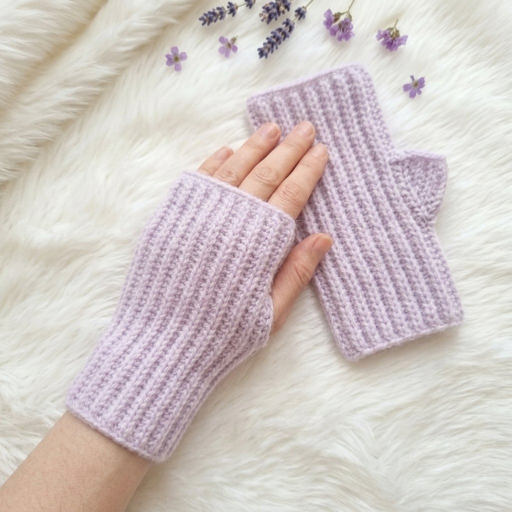 Lavender ribbed fingerless crochet gloves worn on hands with exposed fingers.